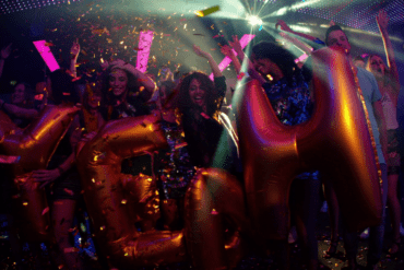 party friends in night club with yeah balloons and confetti rlpz7udwx thumbnail full01